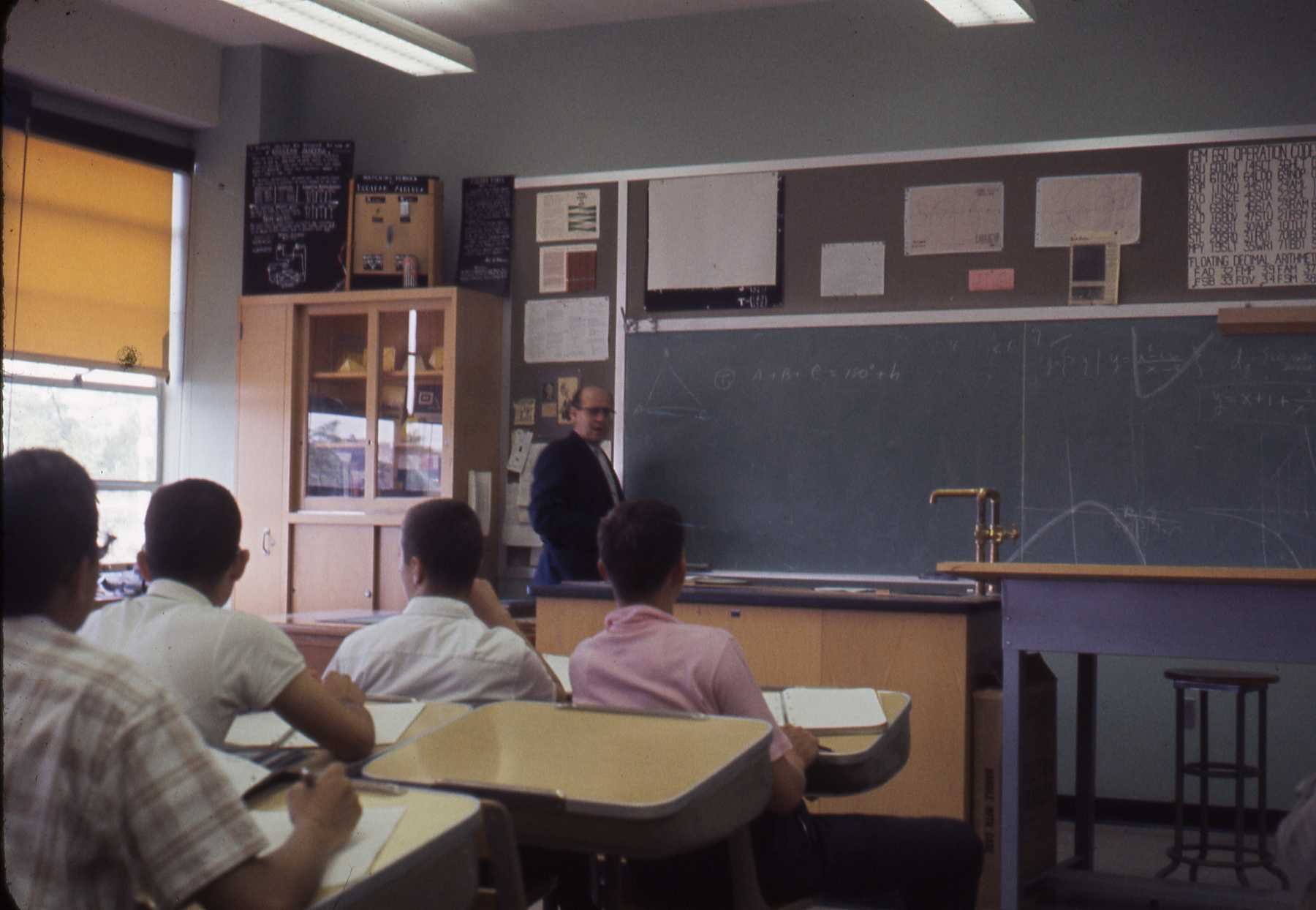Clase de informática con estudiantes frente al pizarrón