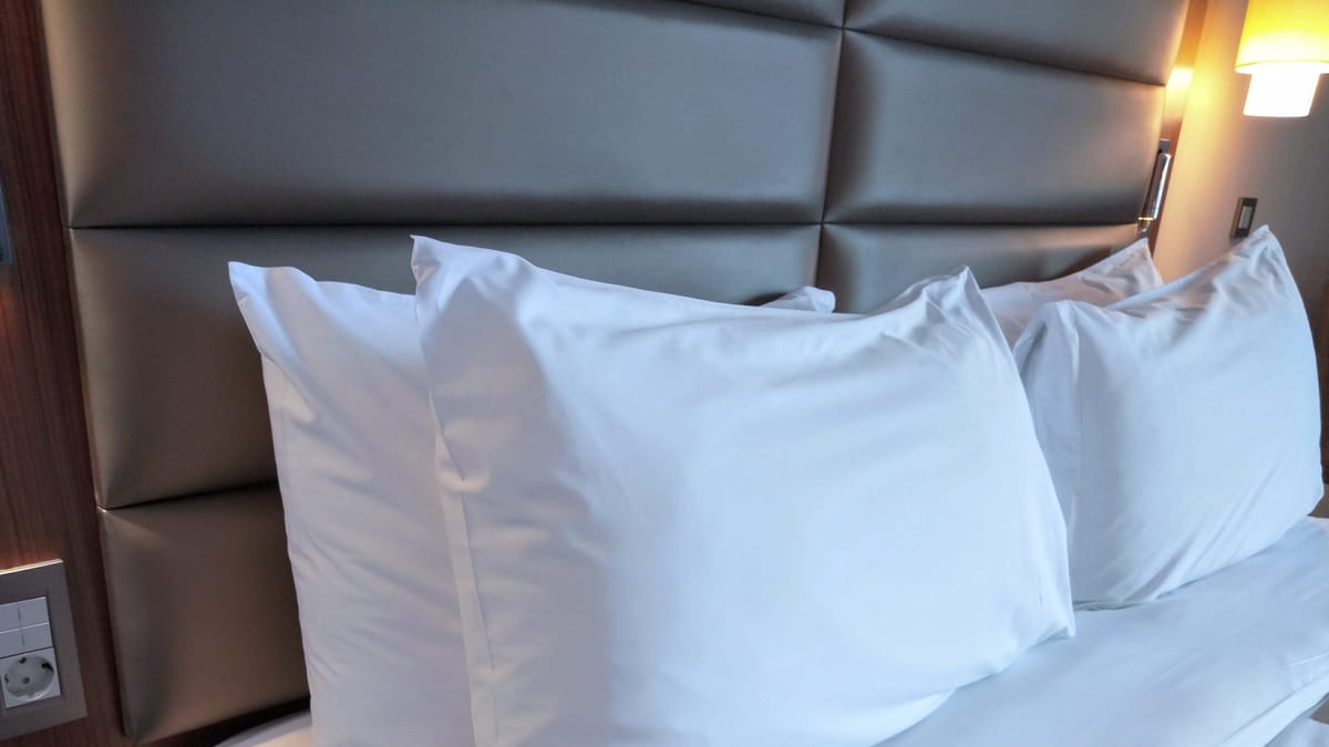 Almohadas blancas reales acomodadas sobre una cama