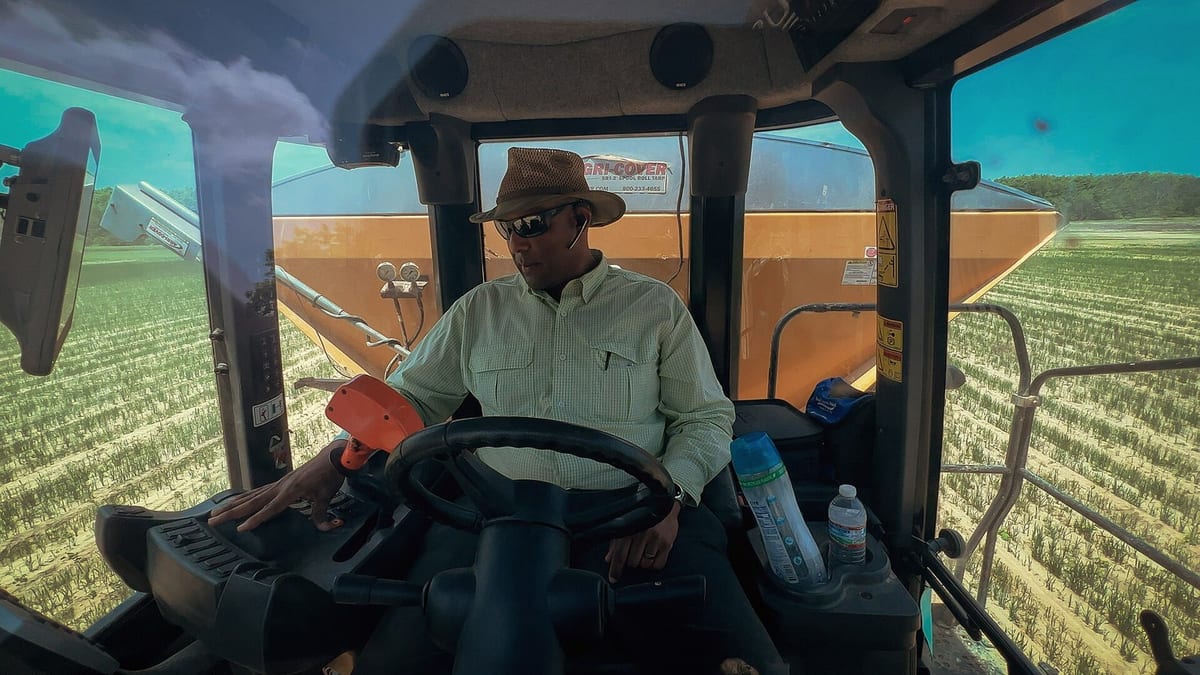 Operador conduce una máquina agrícola durante una cosecha