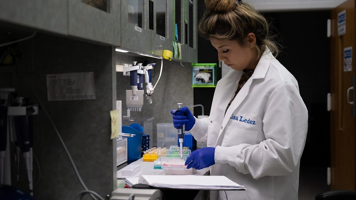 Investigadora trabaja con equipos de análisis genético en un laboratorio