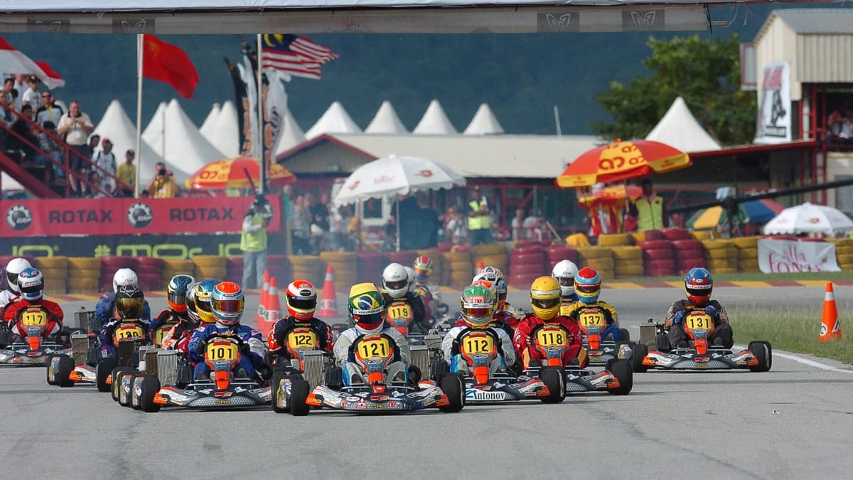 Pilotos de karting preparados en la grilla antes de una largada