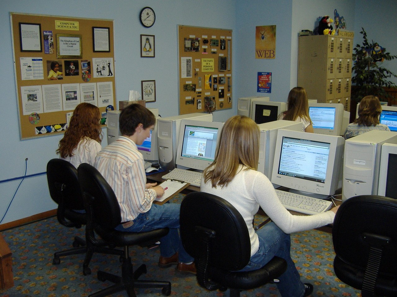 Estudiantes trabajan frente a computadoras en un aula