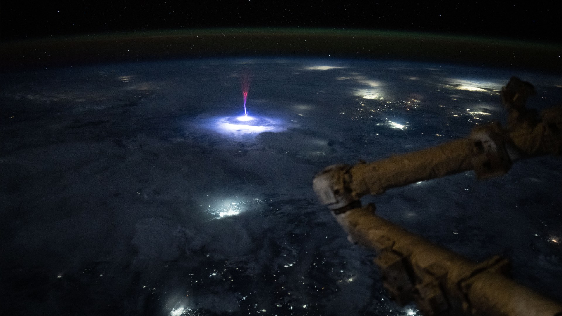 Jet gigante luminoso asciende sobre una tormenta visto desde la estación espacial