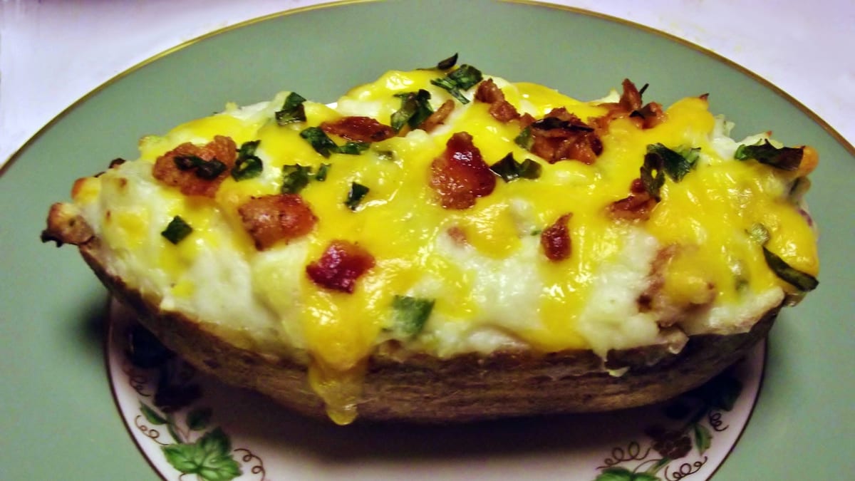 Papa horneada abierta con relleno cremoso y queso gratinado