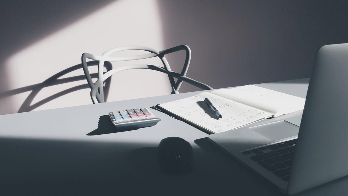 Escritorio con computadora y calculadora para liquidar impuestos