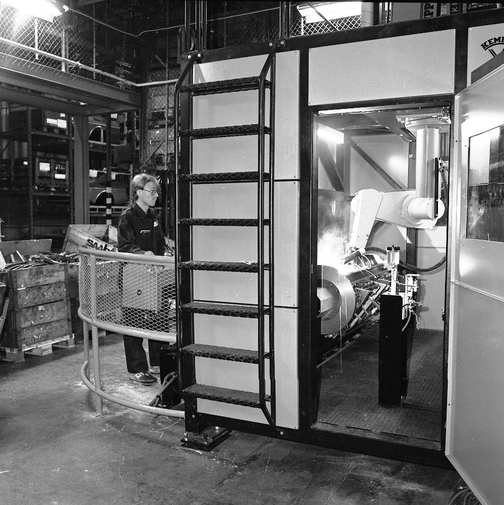 Robot industrial soldando dentro de una fábrica automotriz