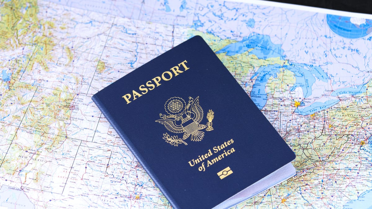 Pasaporte junto a una bandera de Estados Unidos